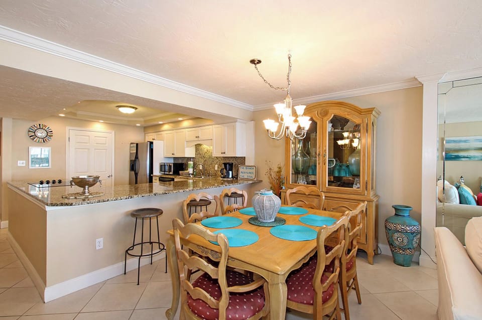 Dining area and kitchen with wrap around large counter top and barstools