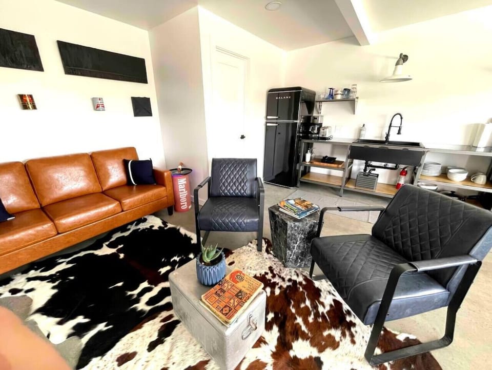 Living area with cowhide rug, cognac leather sofa, and West Texas inspired decor
