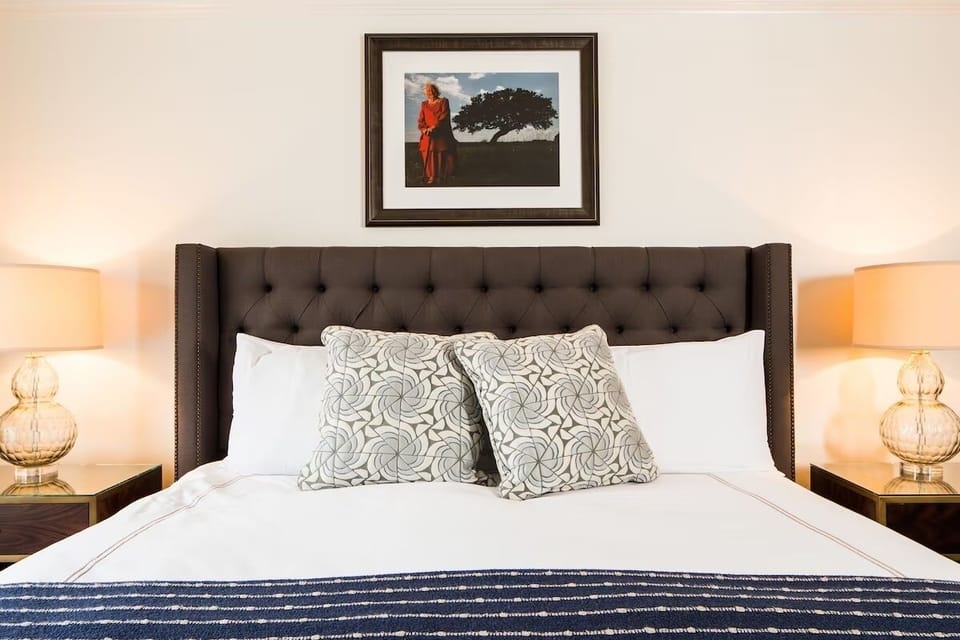 Drift off beneath a plush headboard and warm bedside glow.