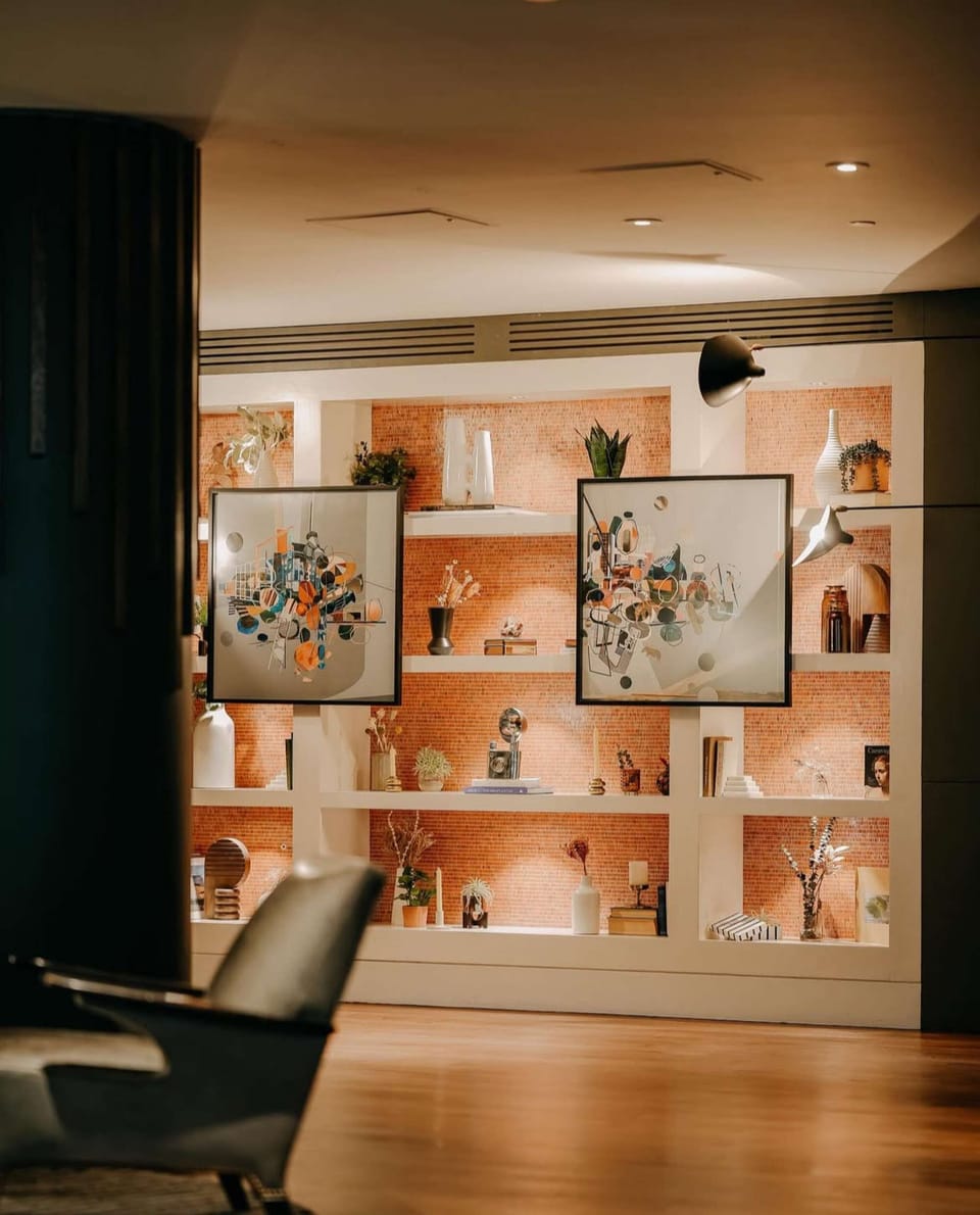 Wall display with framed art, plants, books, and decorative pieces