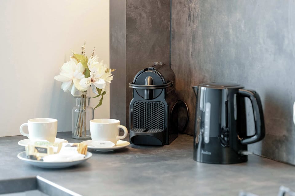 A dedicated corner with a coffee machine, electric kettle, cups, and decorative flowers – ideal for a quick morning pick-me-up or evening tea.