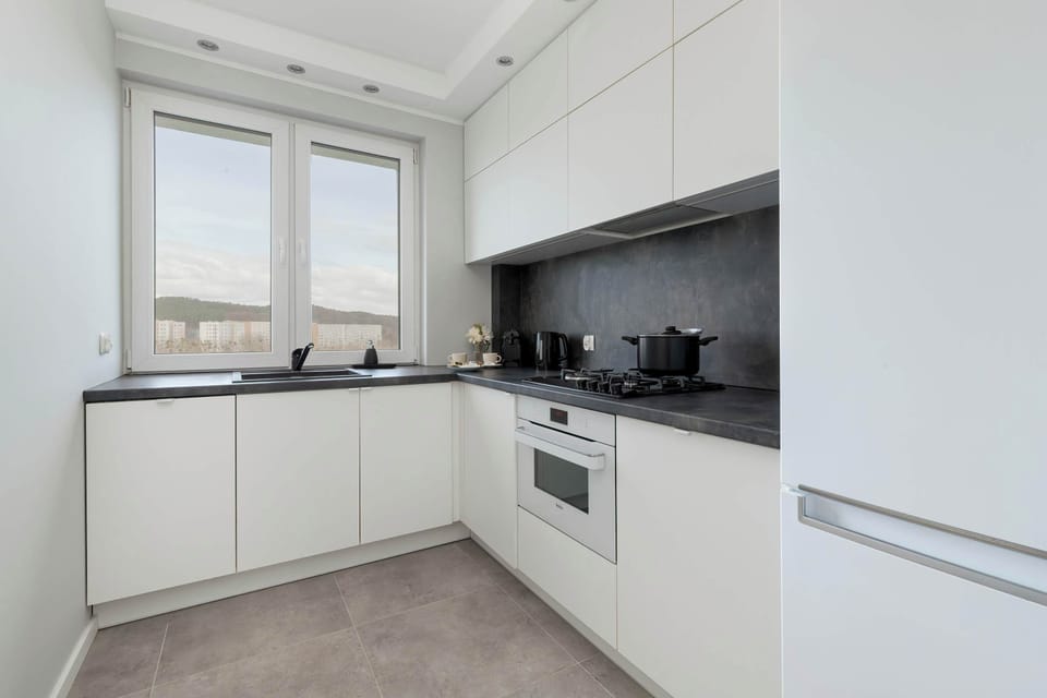 A modern, fully equipped kitchen with white cabinetry and built-in appliances.