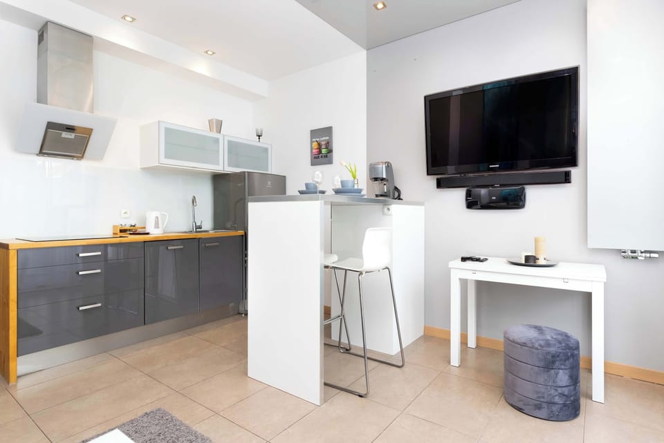 Modern kitchen featuring gray cabinets, a white countertop, and all necessary appliances for convenient cooking.