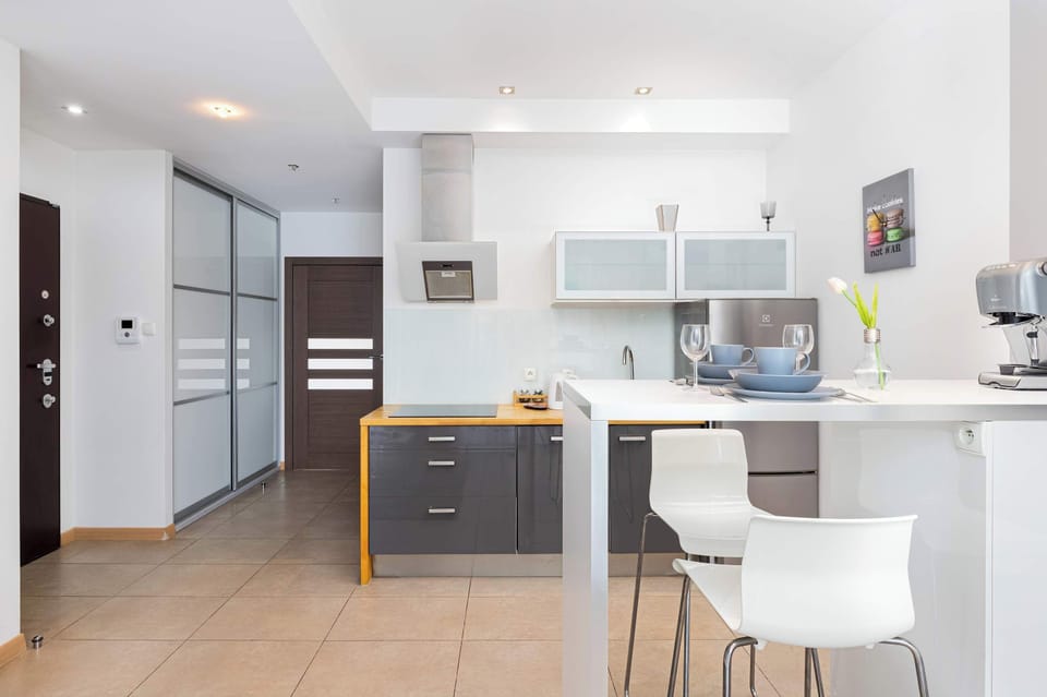 A minimalist dining table and kitchenette with bright and welcoming interiors.