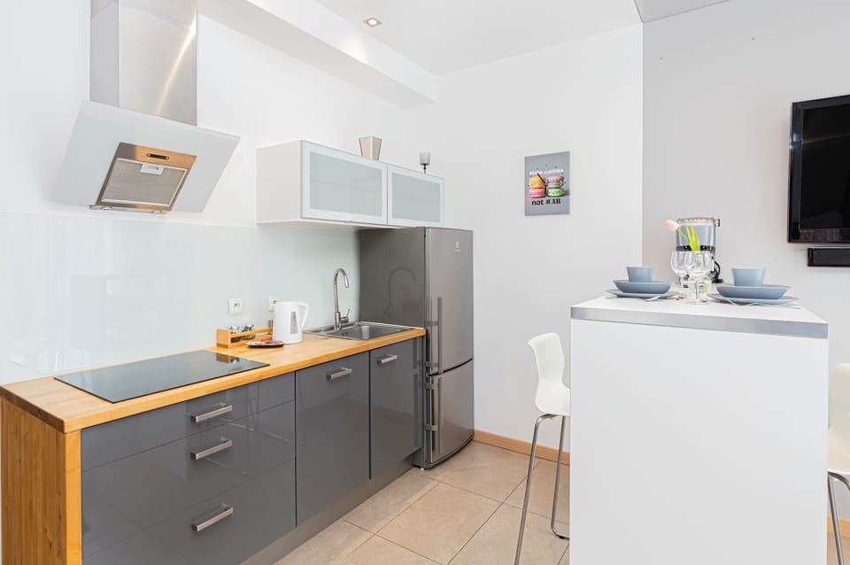 Modern kitchen featuring gray cabinets, a white countertop, and all necessary appliances for convenient cooking.