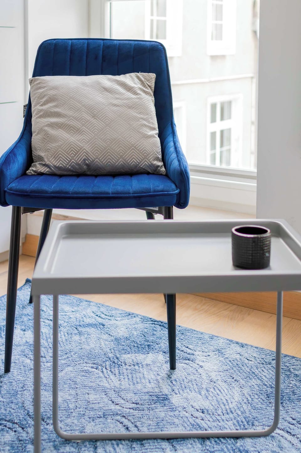 A cozy corner with a modern armchair and fluffy rug, ideal for relaxation.