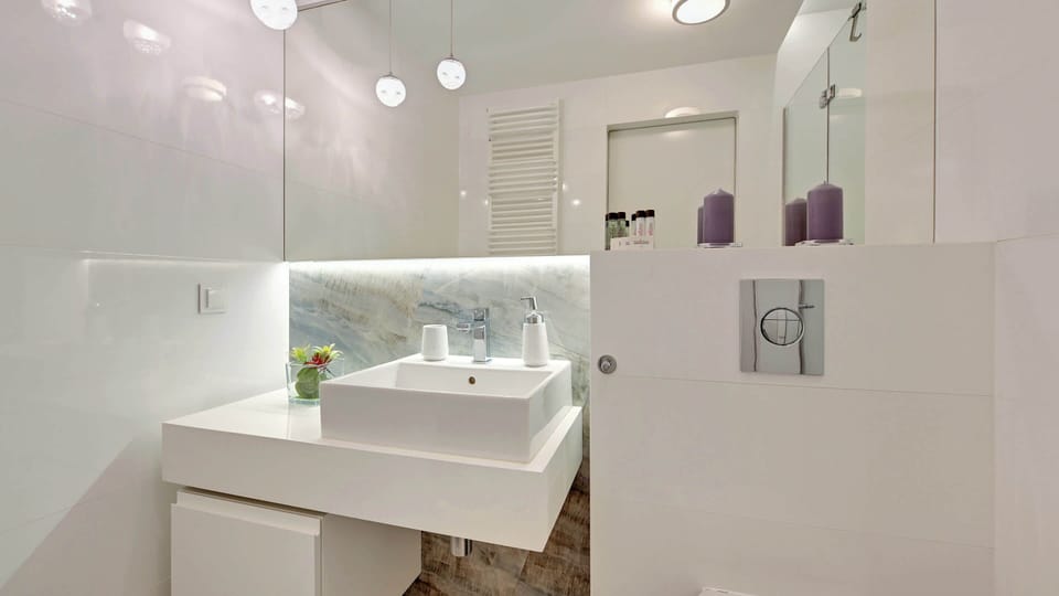A clean and elegant bathroom with light-colored tiles and a stylish vanity area.