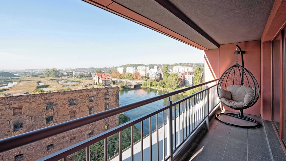 A private balcony with a seating area and a lovely view of the cityscape, perfect for enjoying fresh air and relaxing outdoors.