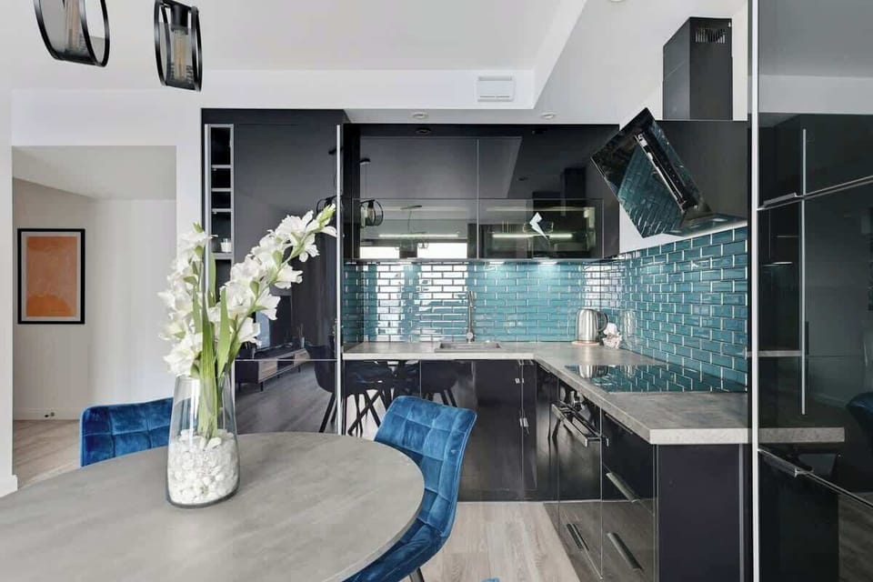 Sophistication with its high-gloss black cabinetry, striking teal subway tiles, and minimalist design, creating a chic and functional culinary space.