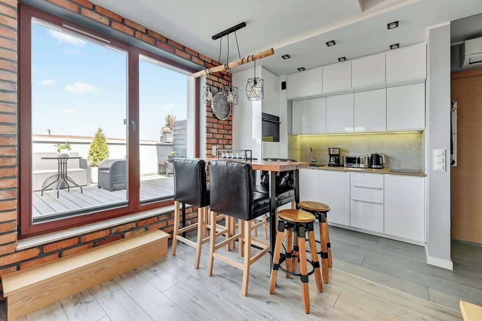 A bright and spacious layout with a dining table by a large window, offering natural light and city views.