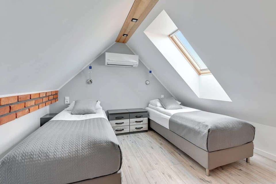 Second bedroom with warm lighting, industrial-inspired details two single beds.