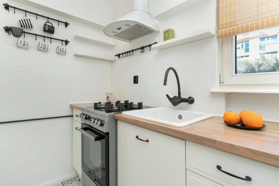 Fully equipped kitchen with gas cooktop, oven, electric kettle, coffee maker, refrigerator with freezer and dishwasher.