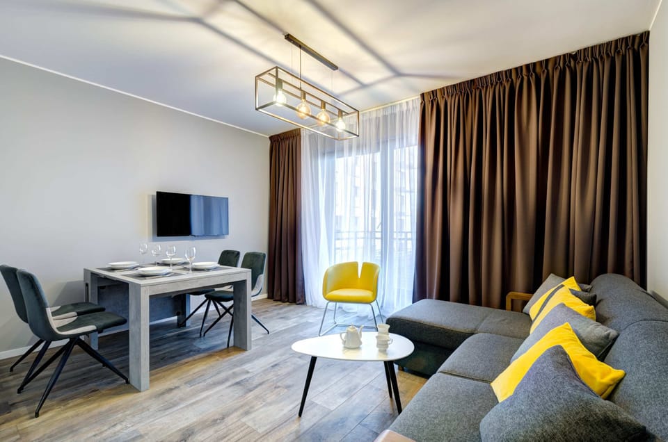 The living area features a sleek coffee table and a flat-screen television.