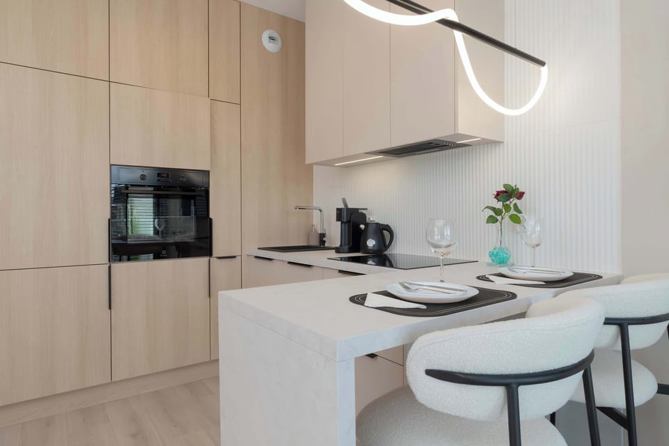 Another view of the kitchenette reveals cabinetry and appliance details, emphasizing its modern and practical nature.