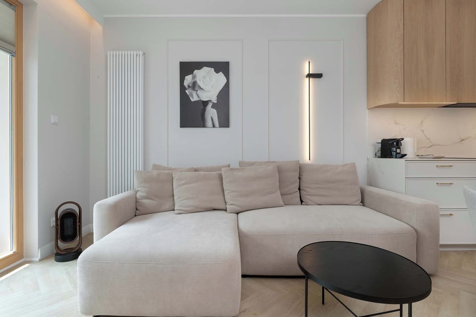 Closer view of the L-shaped sofa and glass doors leading to the balcony.