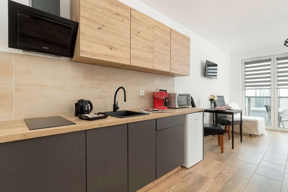 The comfortably furnished kitchenette, equipped with white goods, blends harmoniously with the dining and lounge area to create a functional space.