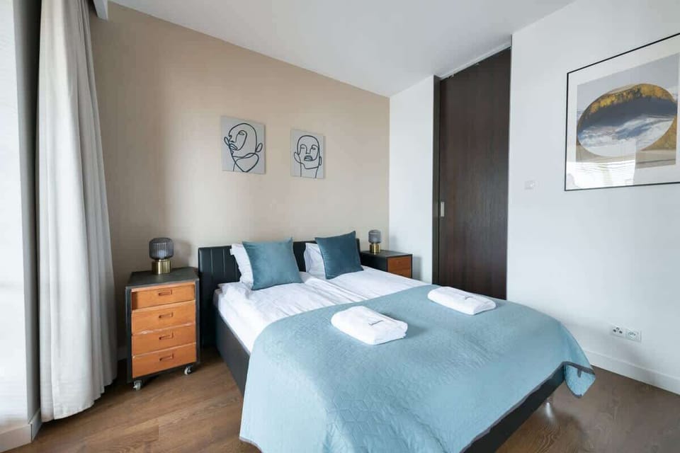 A bright and airy bedroom with comfortable bedding and modern furniture. The decor combines warmth and functionality, ideal for a good night's sleep.