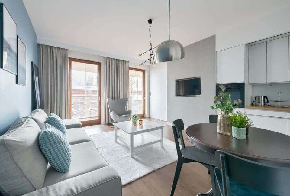 A spacious living area with access to a private balcony. The neutral decor and comfortable furniture provide a relaxing environment.