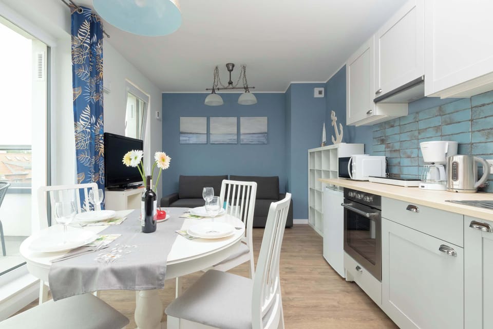 Another view of the main living space and dining area, highlighting the openness and natural light. The dining table seats four people comfortably.