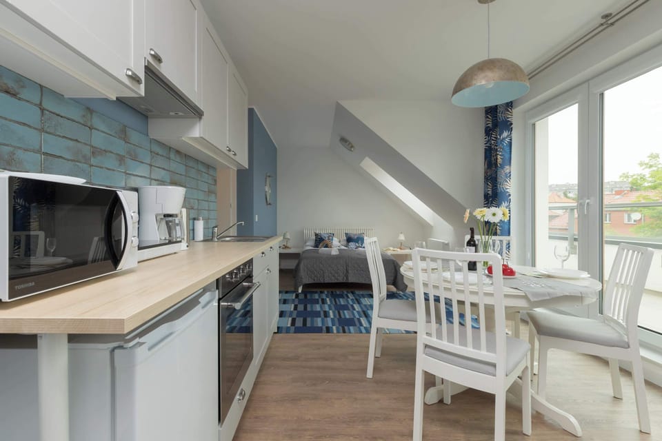 A kitchen equipped with a stovetop, microwave, and ample counter space. The setup is practical and ideal for cooking meals.