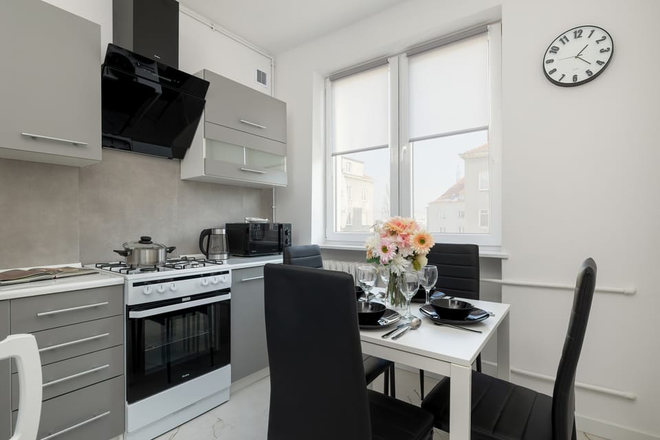Fully equipped kitchen with gas stove and dining area.