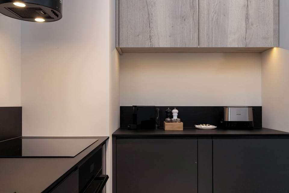Fully equipped kitchenette with modern cabinets and lighting.