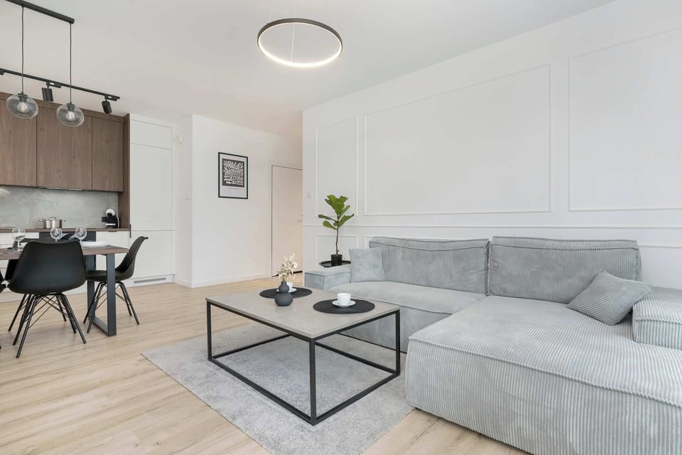 Living room with a corner sofa bed, TV, kitchenette and access to the balcony.