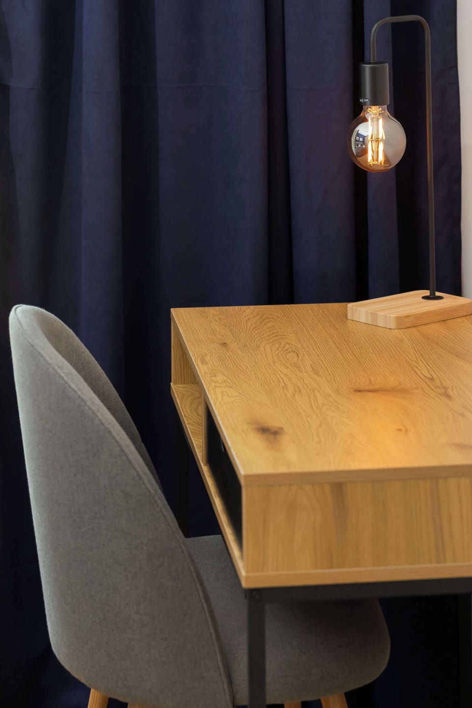 A cozy corner in the bedroom featuring a minimalist desk and a comfortable chair, perfect for working or studying.


