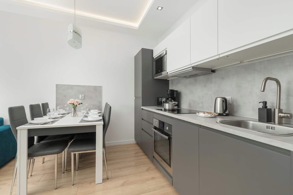 Dining table with fully equipped kitchenette to enjoy shared meals.
