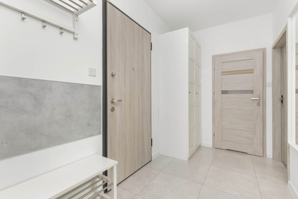 A hallway with light-colored walls and a door leading to another room, connecting spaces.