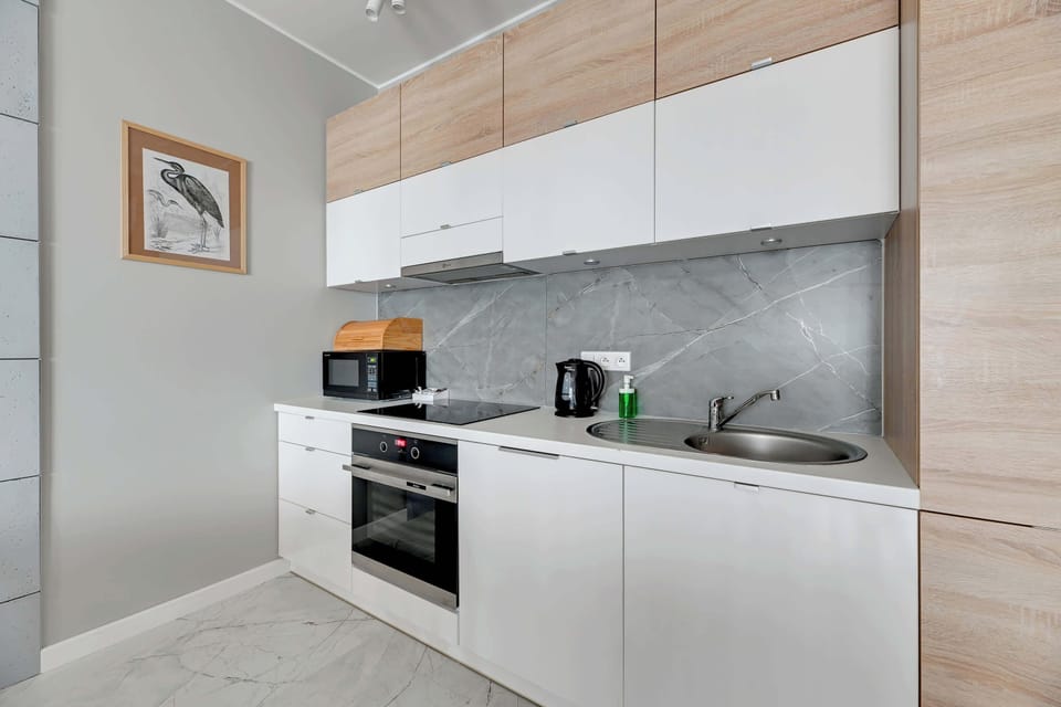 A modern kitchen with wooden elements, a dining area, and pendant lights.
