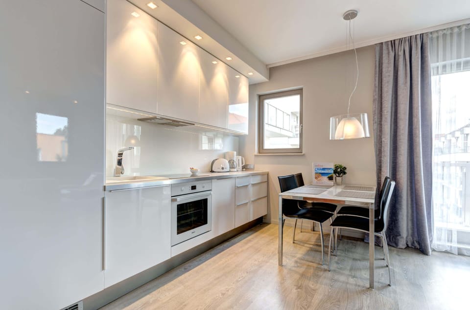 A kitchenette with lacquered fronts adds elegance while providing plenty of space for preparing meals. 