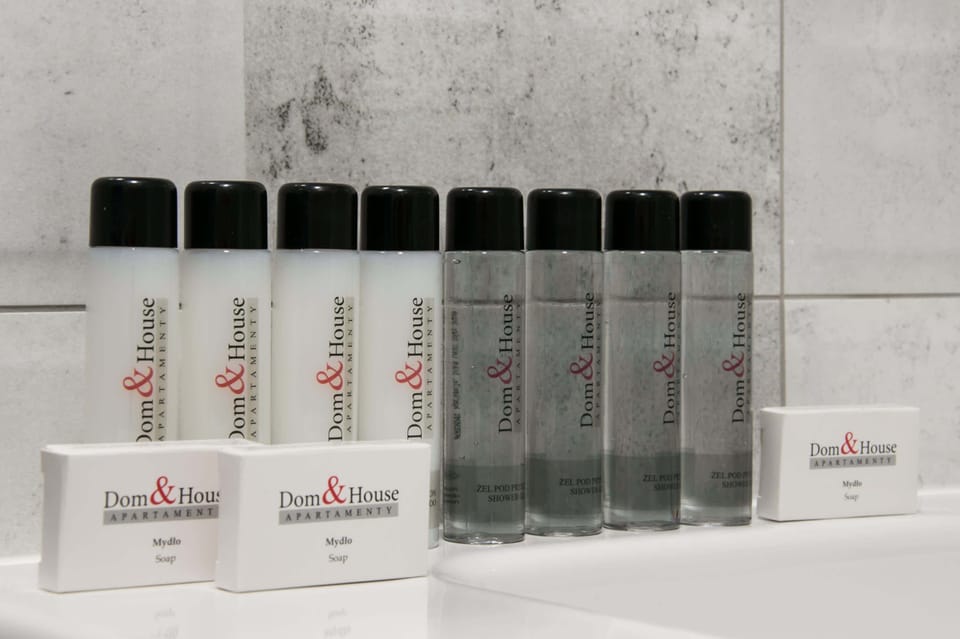 A close-up of complimentary toiletries provided for guests, displayed on a shelf in the bathroom.