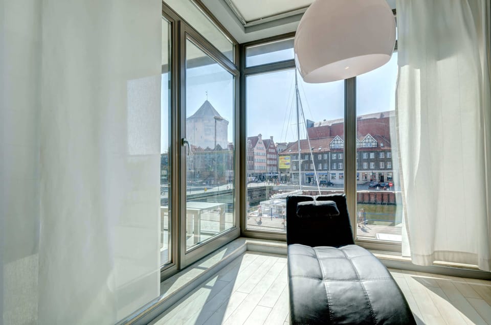 A bright living space with glass doors, modern furniture, and plenty of natural light. A welcoming area to relax and socialize.