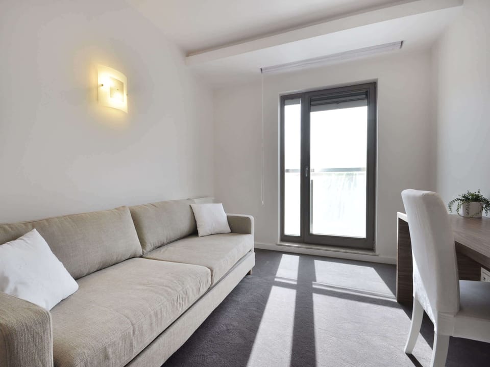 The centerpiece of the living room is the comfortable corner sofa, offering a perfect spot to unwind after a busy day. The space is thoughtfully arranged to promote togetherness, from movie nights on the large flat-screen TV to cozy conversations.