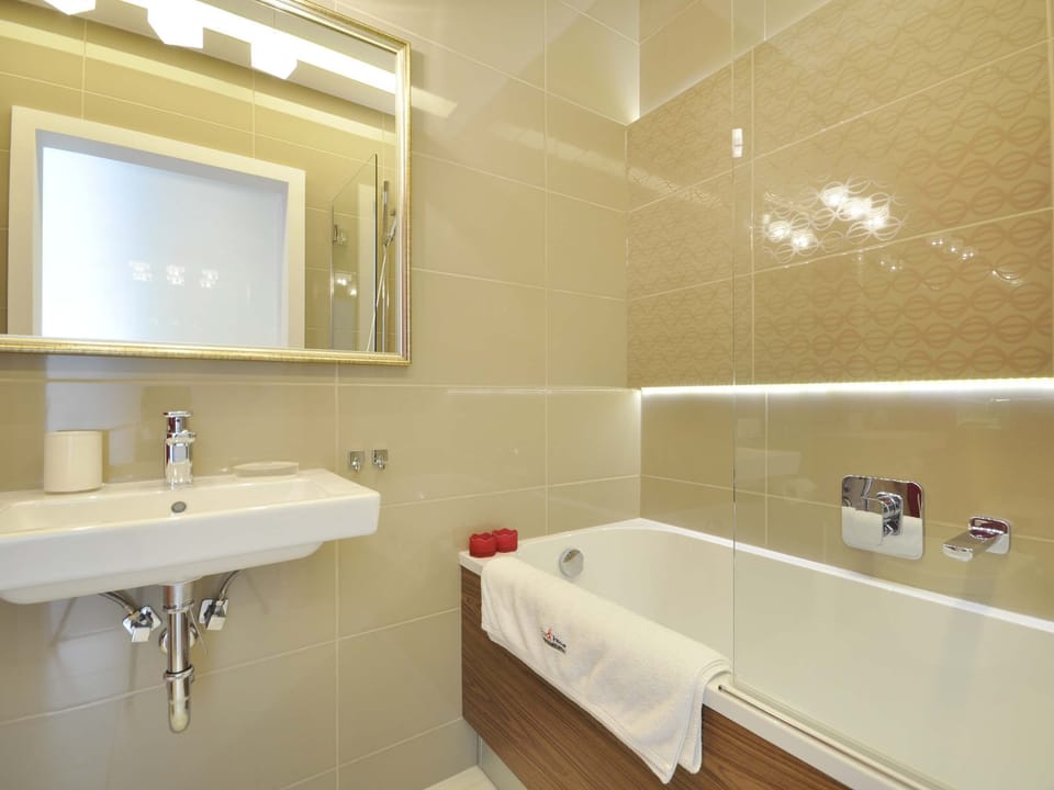 The bathroom, finished in warm beige tones, is designed with both functionality and aesthetics in mind. 
