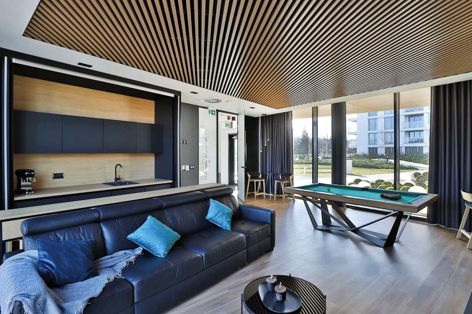 A sophisticated common space with a billiard table and decorative lighting, ideal for relaxation and fun.