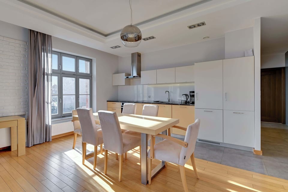 An elegant dining space with a table and upholstered chairs, seamlessly integrated with a contemporary kitchen design.