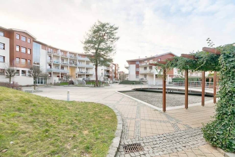 A tranquil neighborhood scene with paved paths, greenery, and a sense of modern community.