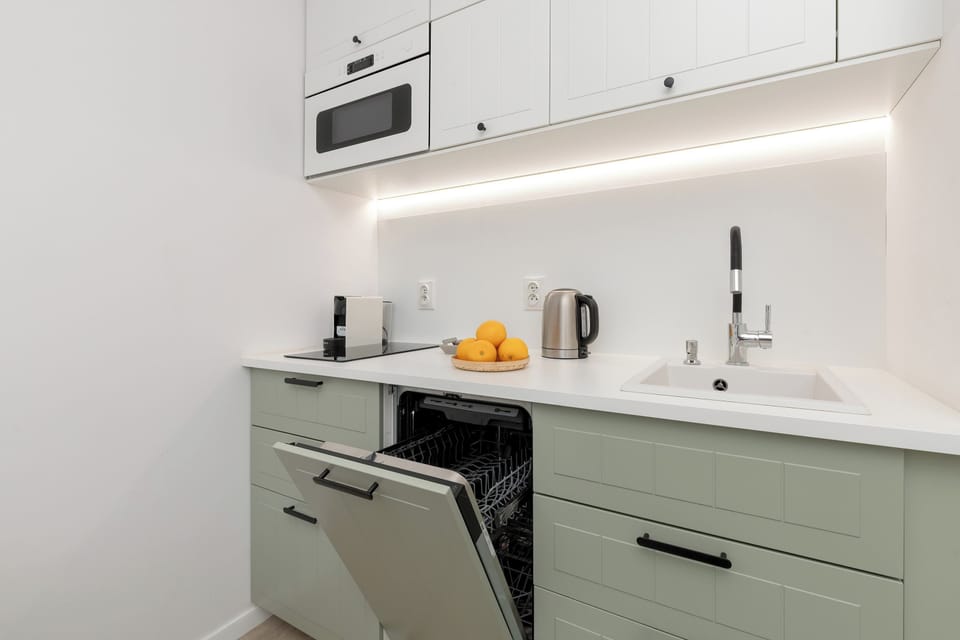 Another view of the kitchenette showcases its functionality, with a clean white countertop, a stovetop, and essential kitchen appliances ready for use.