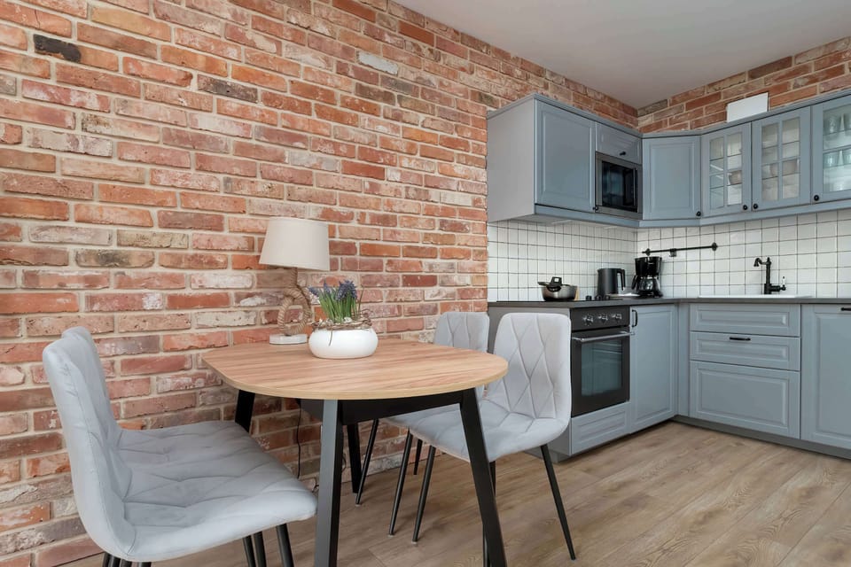 Fully equipped kitchenette with electric hob, oven, refrigerator, freezer, microwave, dishwasher, electric kettle, coffee maker, sandwich maker and dining area.