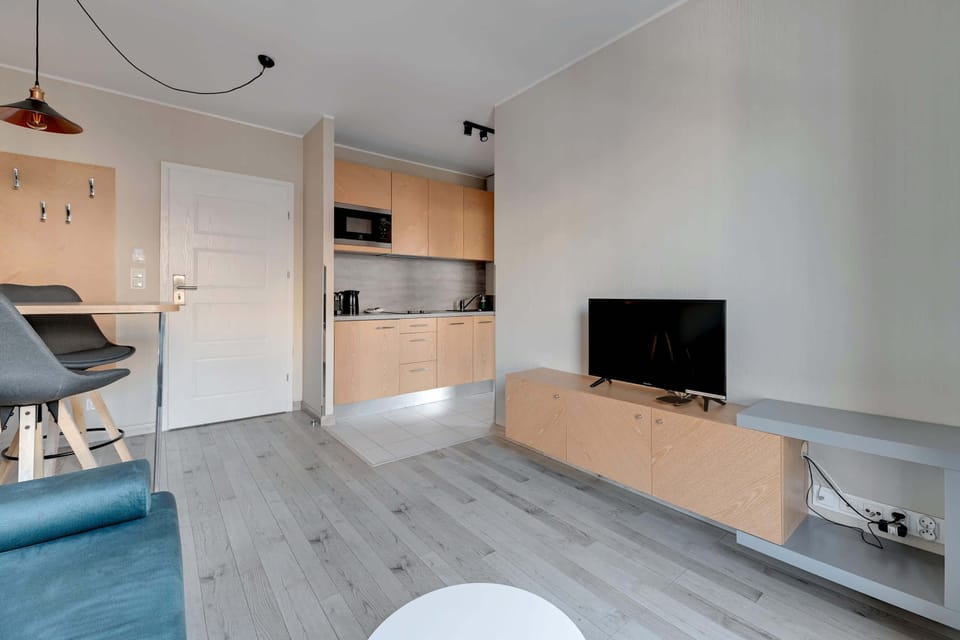 A view of the dining space shows its integration with the living area. The blue accent wall and stylish chairs bring vibrancy to the minimalist decor.