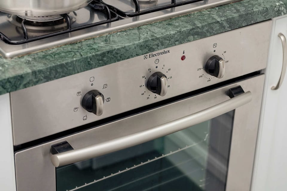 A close-up of the oven and stovetop in the kitchen, highlighting the sleek, stainless-steel design.