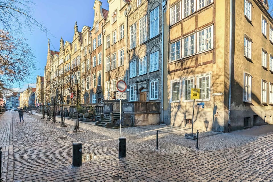 A bustling street surrounded by colorful buildings and pedestrians enjoying the vibrant atmosphere.