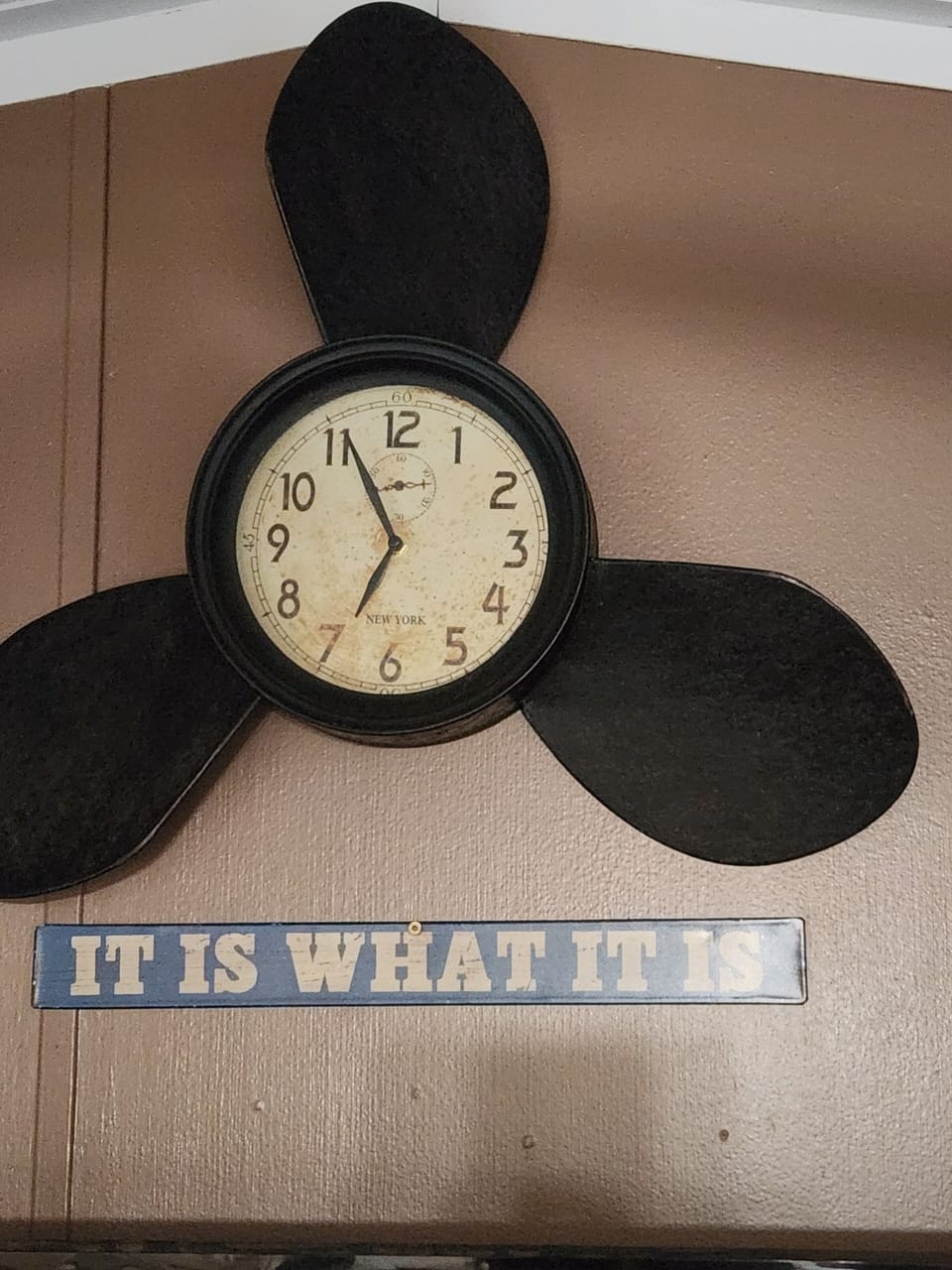 Cool prop clock above the giant TV in the living room "It is what it Is"