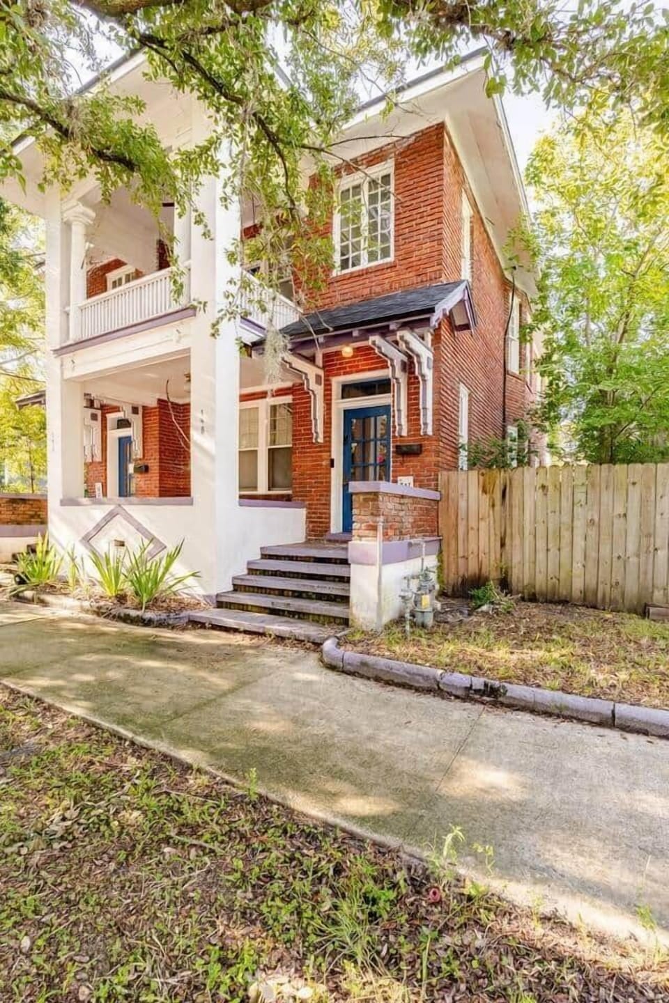 Welcome to our charming historic duplex! Guests at 148 W 6th St (upstairs unit) enter through the right-side staircase and black door. Enjoy the unique brick exterior, bold trim, and warm Southern welcome from the moment you arrive.

