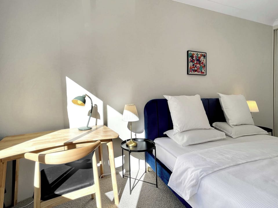 Bedroom showing twin-style configuration (king bed setup), bedside lighting, and neutral décor.