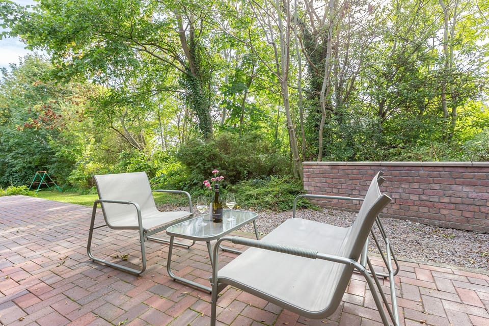 Terrace with chairs and table in greenery