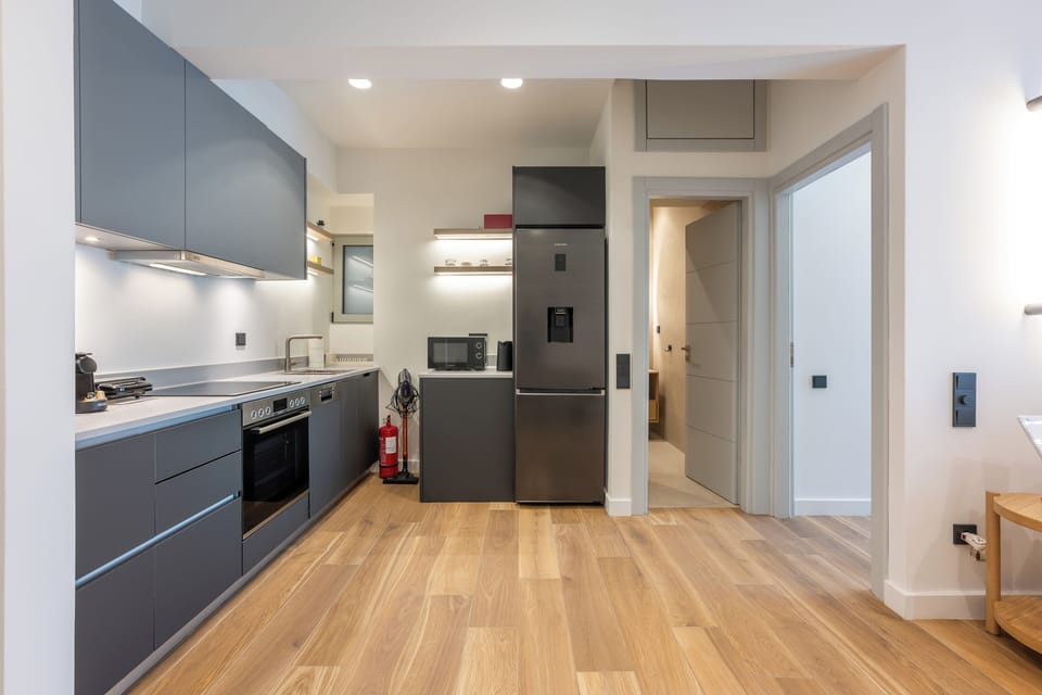 Modern kitchen with sleek design, ample lighting, and warm wooden flooring.