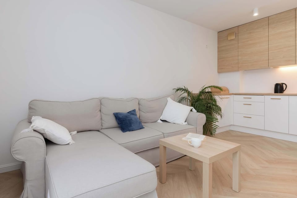A cozy sitting area in bright colors with a soft sofa, decorative pillows and plants promotes relaxation and tranquility.